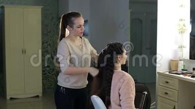 美发师在沙龙为客人做大辫子。在美容院编织辫子